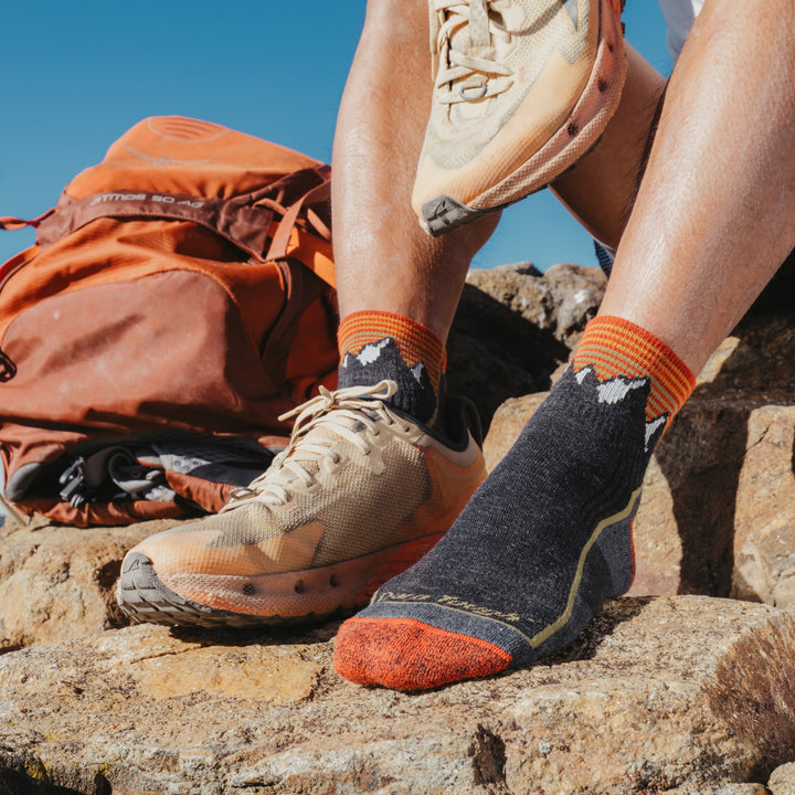 Close up of models feet one shoe off wearing the 1959 quarter midweight hiking sock in mountain gray