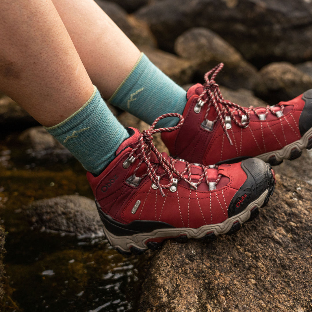 Close up image of a woman's feet, wearing Women's Light Hiker Micro Crew Hiking Socks in Aqua with red hiking boots, Lifestyle Image