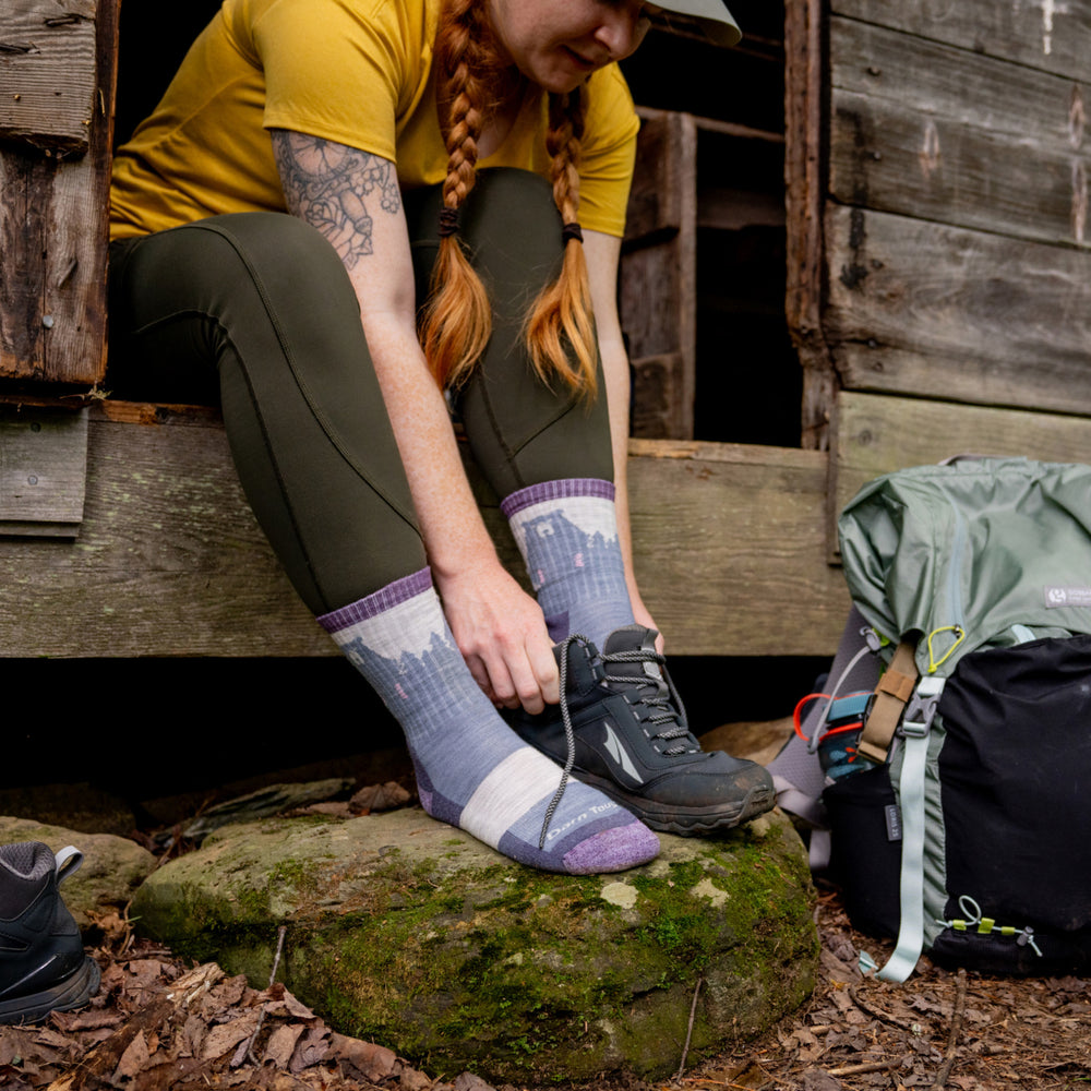 model sitting in doorway putting on shoes wearing the 1970 beartown in fog