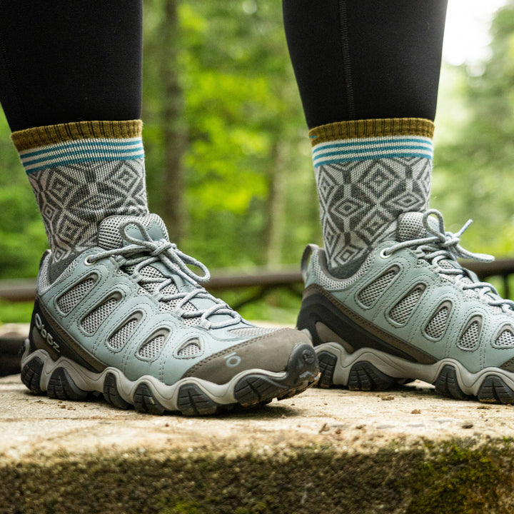 Close up image of a woman's feet wearing sneakers and Women's Sobo Micro Crew Lightweight Hiking Socks in Gray