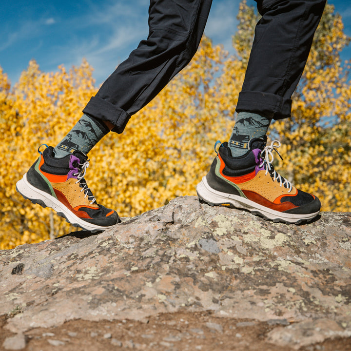 model climbing rock wearing the 5021 hut hut hike micro crew hiking sock in seafoam colorway