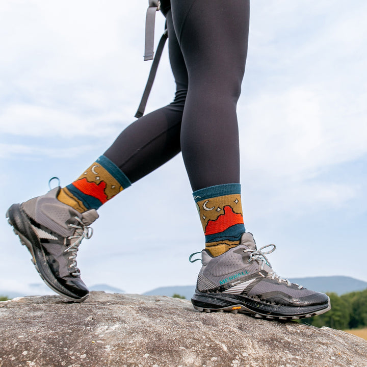 model walk on rocky surface wearing the 5023 celeste micro crew hiking sock in sandstone 