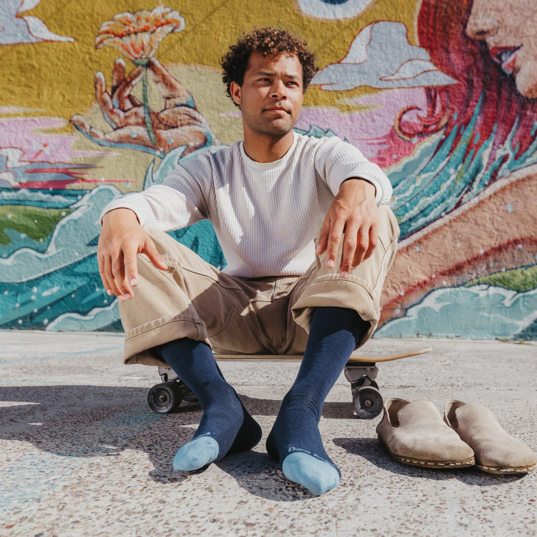 model sitting on skateboard with shoes off wearing 6032 solid lightweight lifestyle crew sock in eclipse vapor colorway