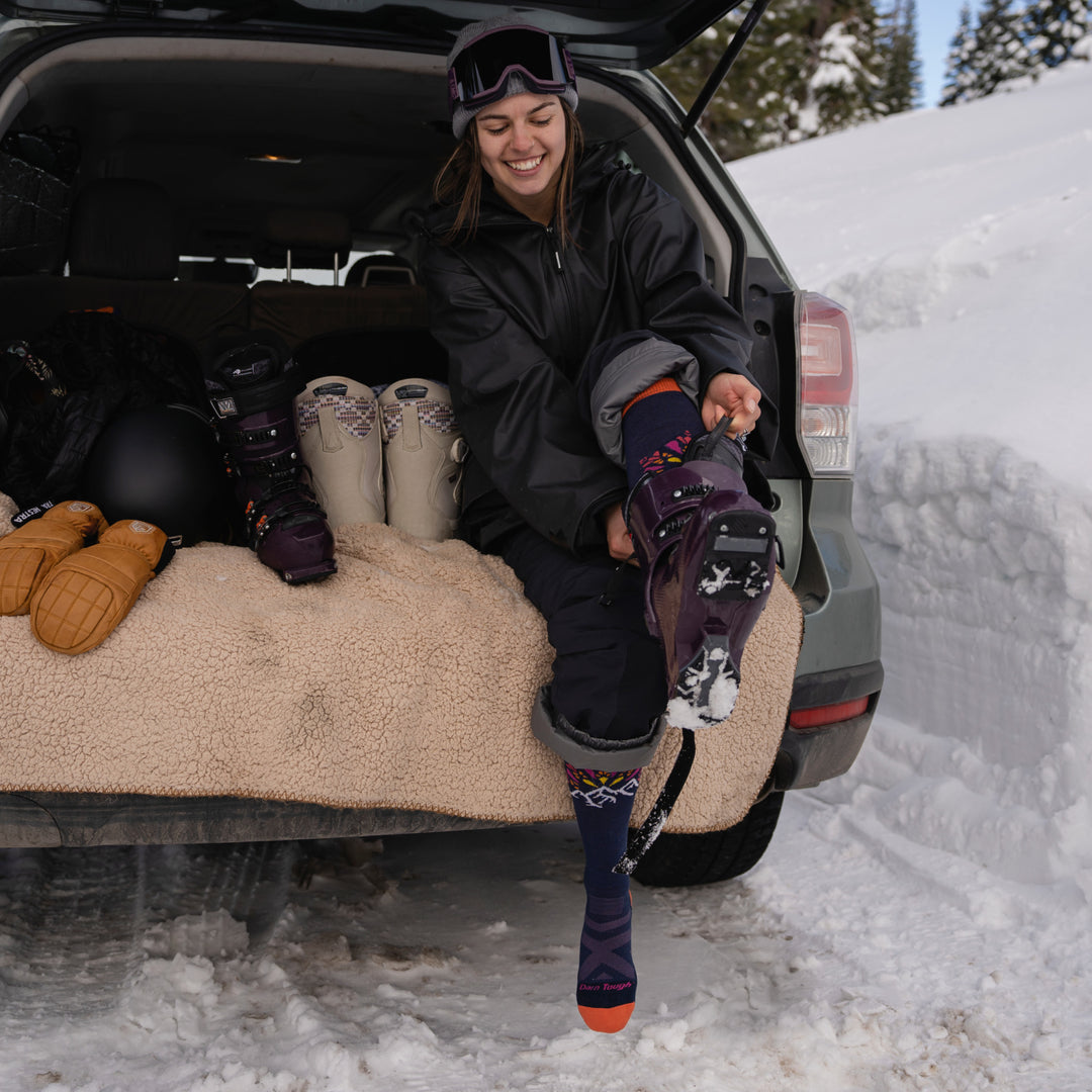 Model sitting in the back of vehicle putting on boots wearing the 8039 Daybreak in Eclipse