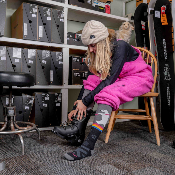 Model putting on ski boot wearing the 8041 due North Thermolite Ski and Snowboard sock in Black