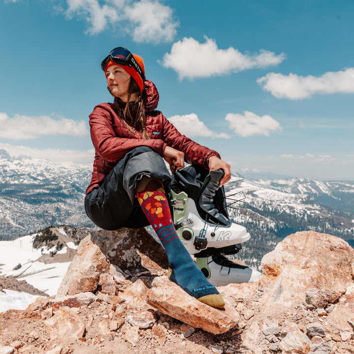 model sitting on Mountain top putting on boot wearing the 8046 autumn