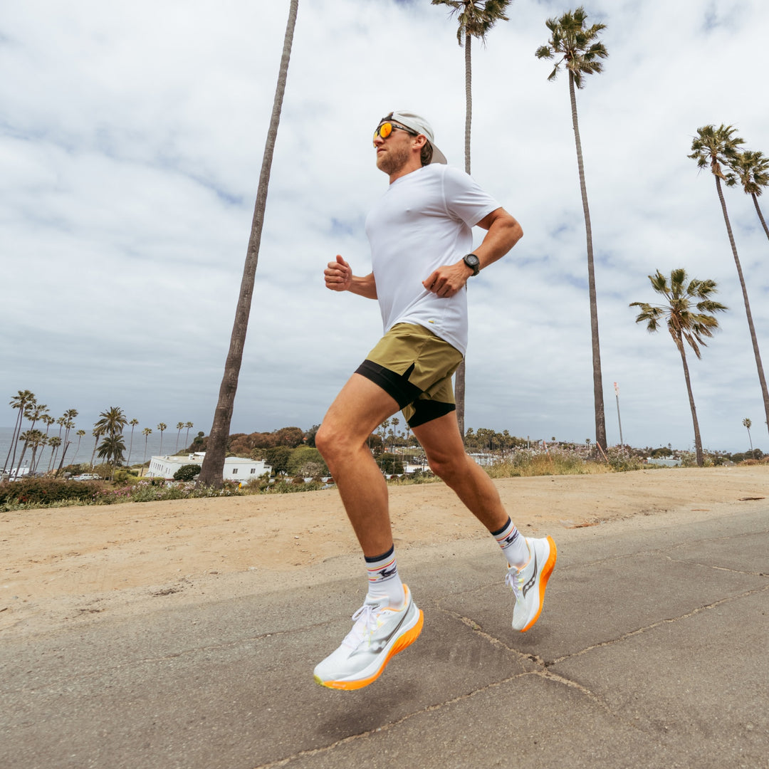 model running next to the beach wearing the 1062 front runner micro crew running sock in white colorway