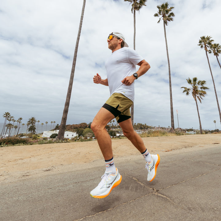 model running next to the beach wearing the 1062 front runner micro crew running sock in white colorway