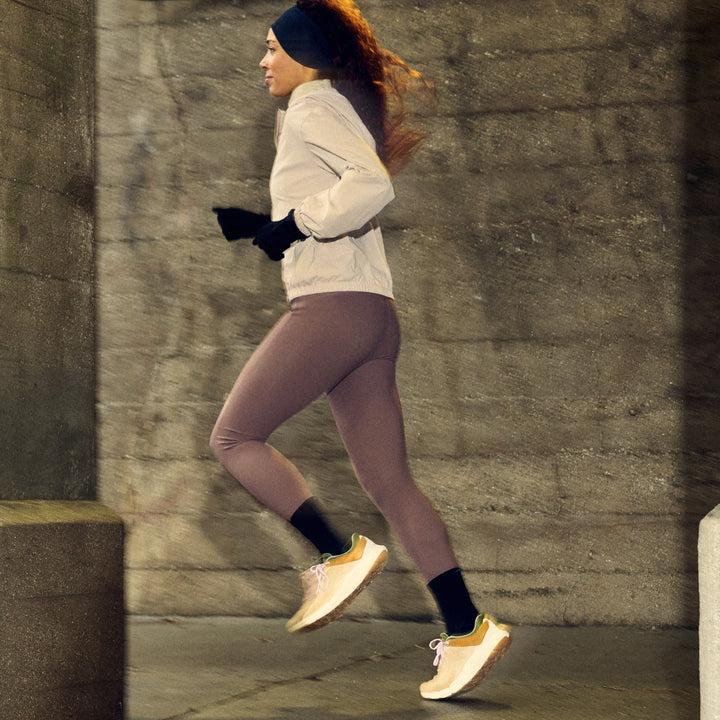 woman running on sidewalk at night in purple leggings and white jacket wearing 1072 run micro crew ultra lightweight with cushion black sock