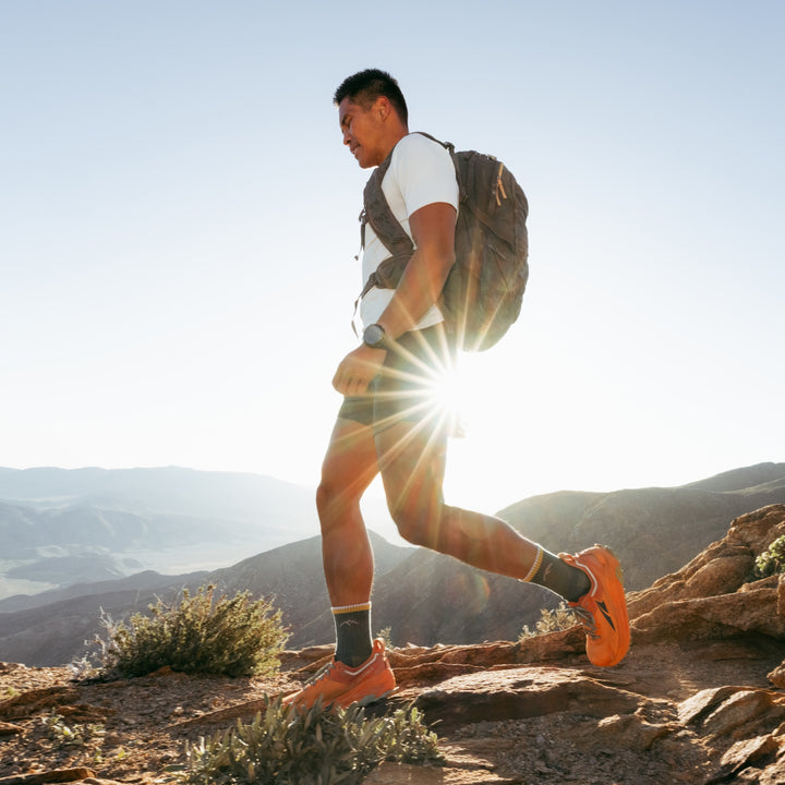 Model walk on the top of the summit wearing the 1466 midweight micro crew hiking sock in spruce colorway