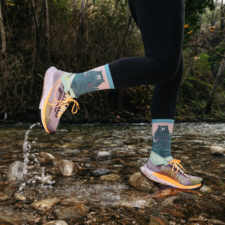 Model running through water wearing the 19070 Beartown Micro crew hiking sock in Quartz