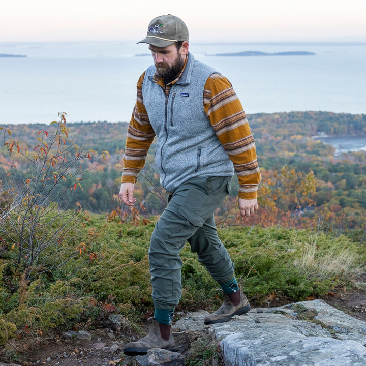 model walking on trail wearing the 5003 willoughby micro crew hiking sock in dog pond blue colorway