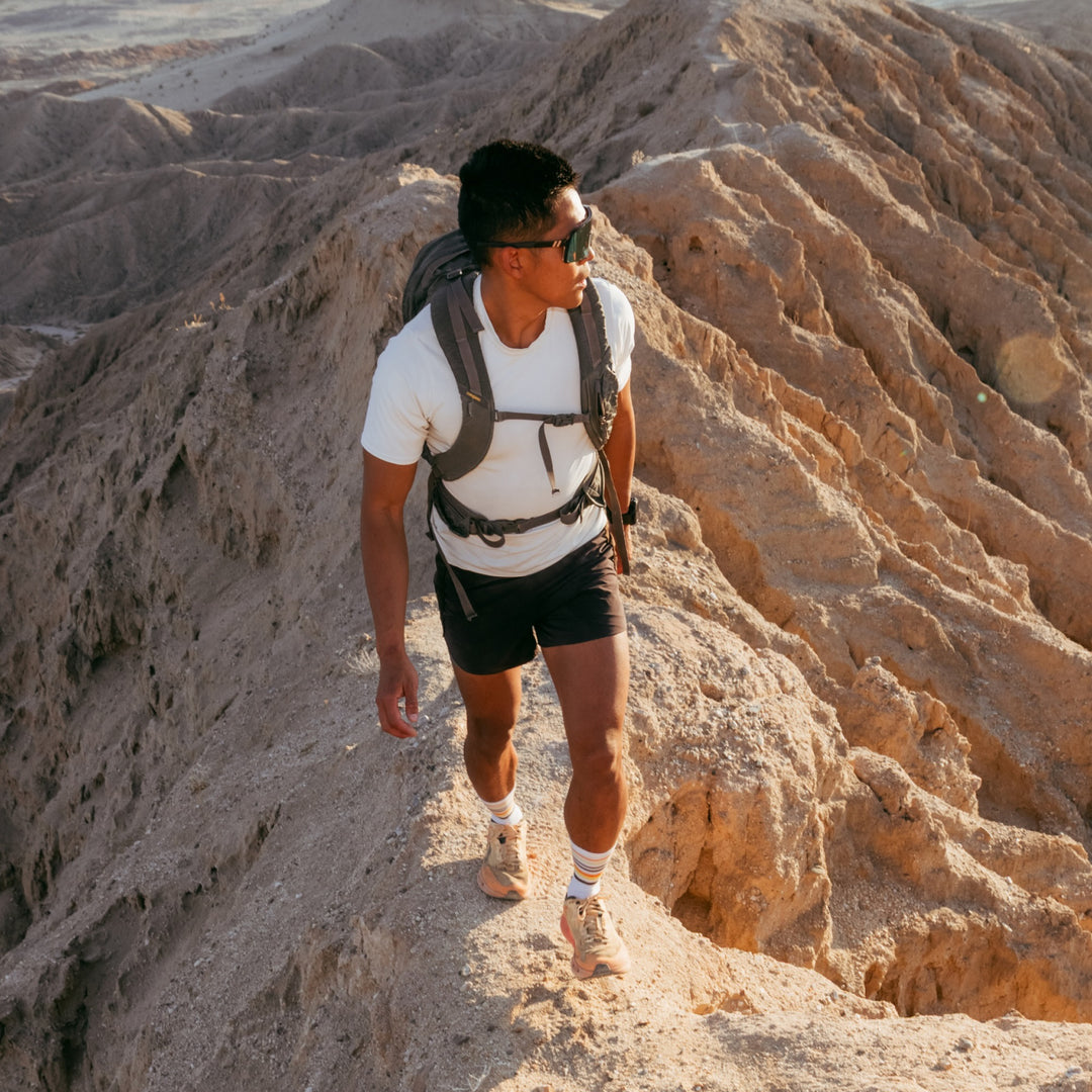 model walking the ridgeline wearing the 5012 fastpack lightweight micro crew hiking sock in white colorway