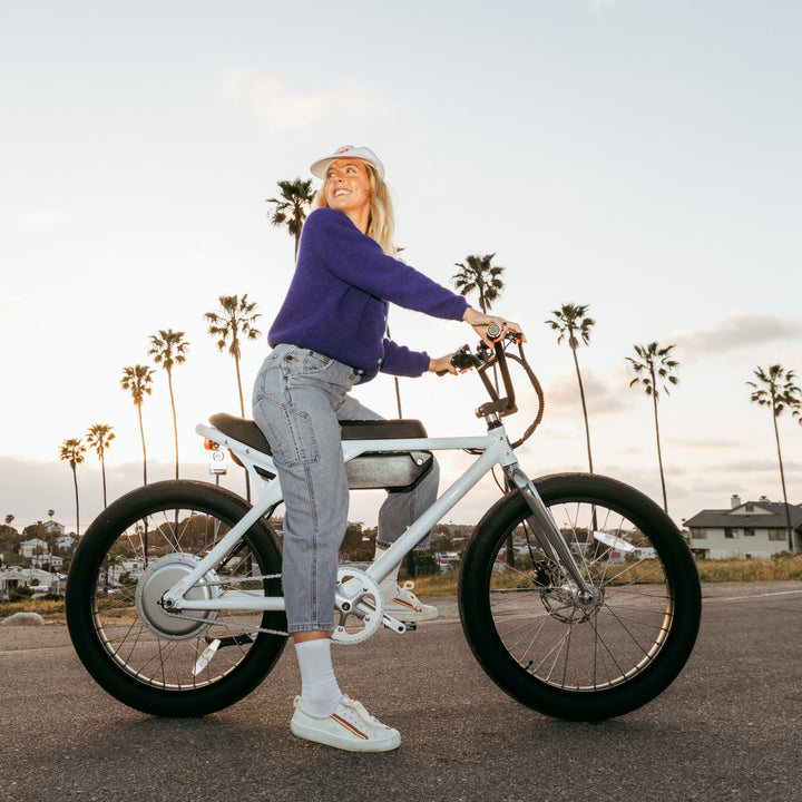 model riding a bicycle wearing the 6012 solid lightweight lifestyle crew sock in white colorway