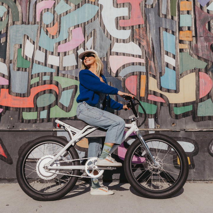 model on bicycle wearing the 6037 animal haus lightweight lifestyle crew sock in bunny blue colorway