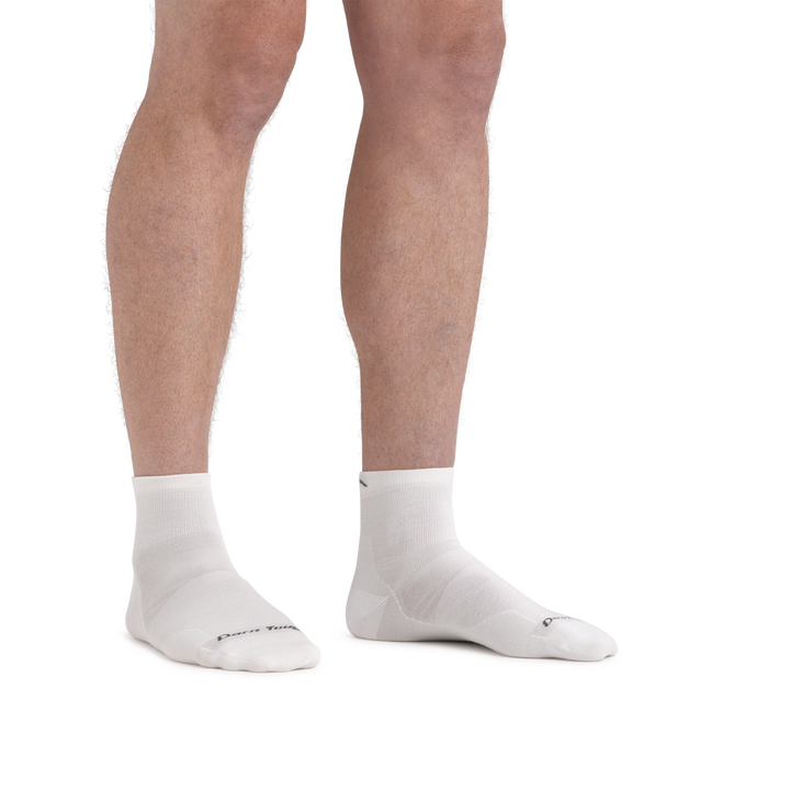 Man standing barefoot wearing Run Quarter Ultra-Lightweight Running Socks in White
