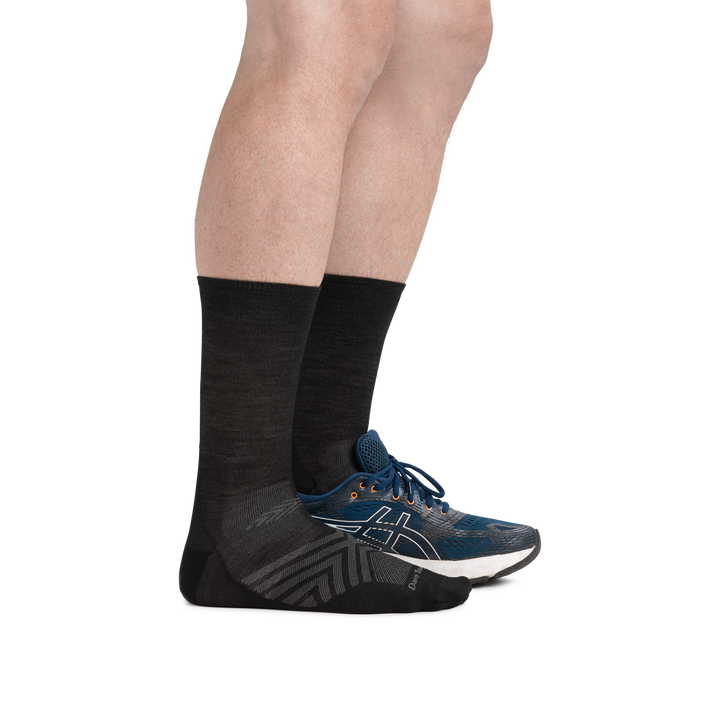Man wearing Run Micro Crew Ultra-Lightweight Running socks in Black with back foot also in a running shoe
