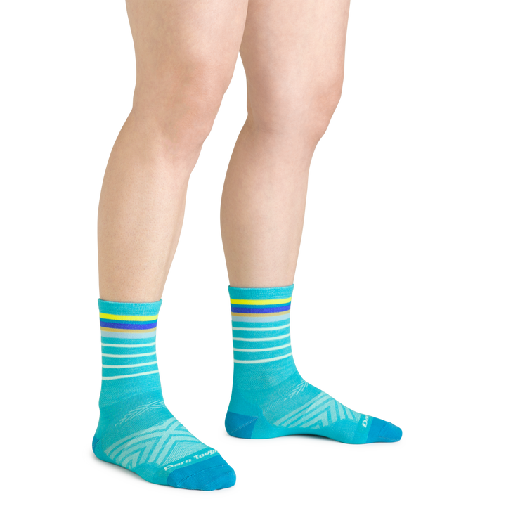 Close up shot of model wearing the women's stride micro crew running sock in teal with no shoes on