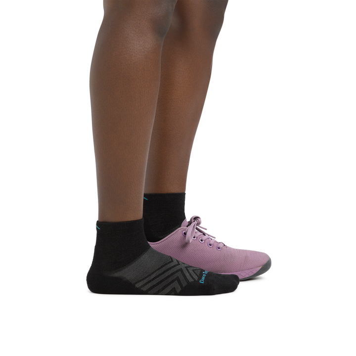Woman wearing Women's Run Quarter Ultra-Lightweight Running Socks in Black with a running shoe on one foot