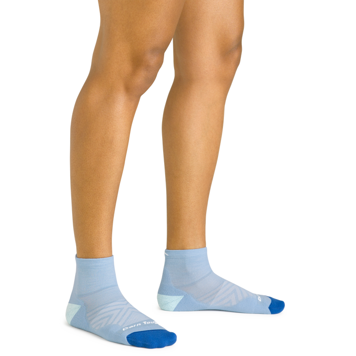 Close up shot of model wearing the women's quarter running sock in sky blue with no shoes on