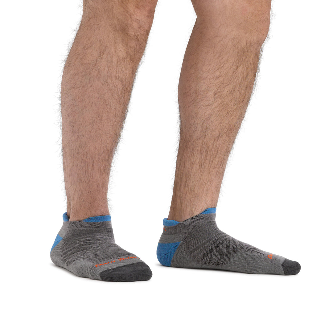Studio photo of model wearing men's coolmax run no show running socks in gray.