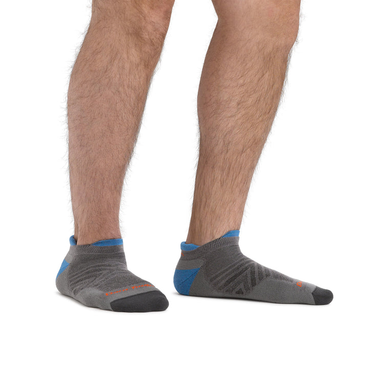 Studio photo of model wearing men's coolmax run no show running socks in gray.