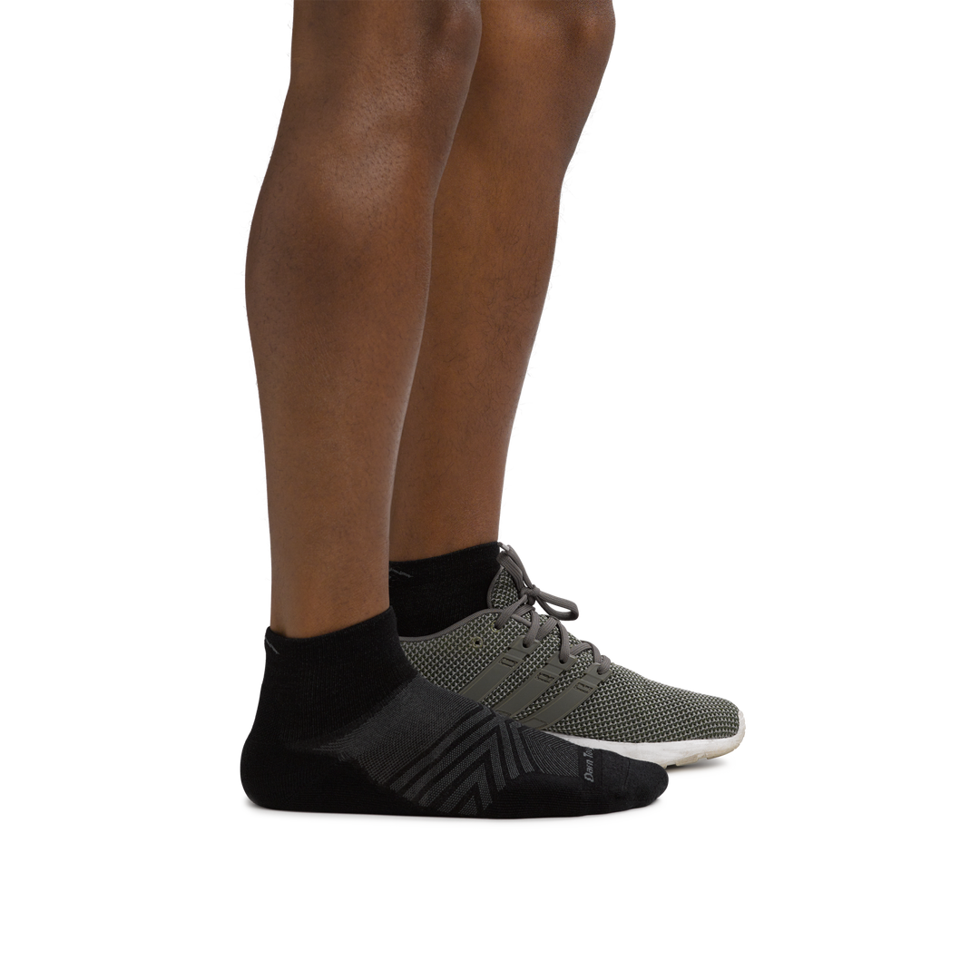 Man facing right wearing Coolmax Run Quarter Ultra-Lightweight Running Sock in Black with back foot in a running shoe