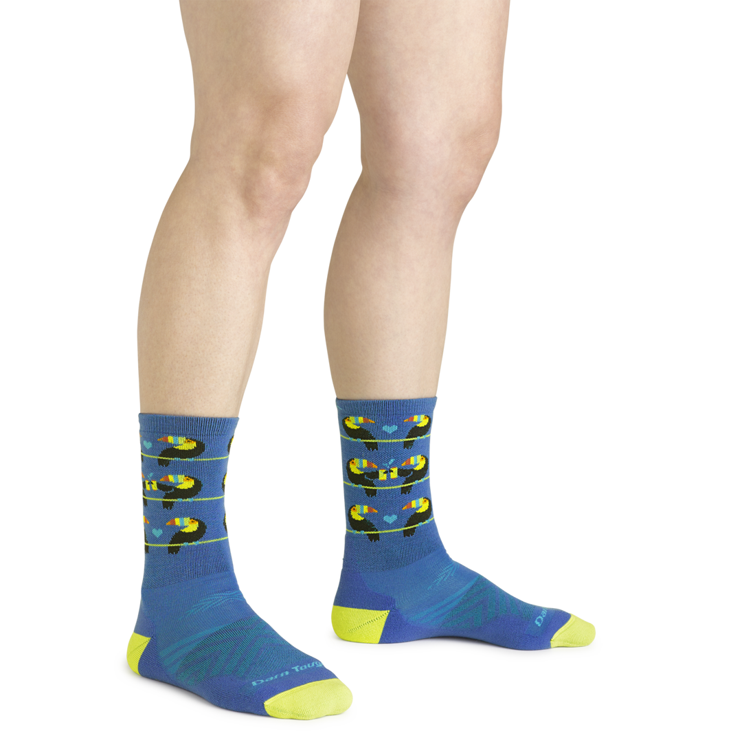 Close up shot of model wearing the women's toco loco micro crew running sock in baltic blue with no shoes on