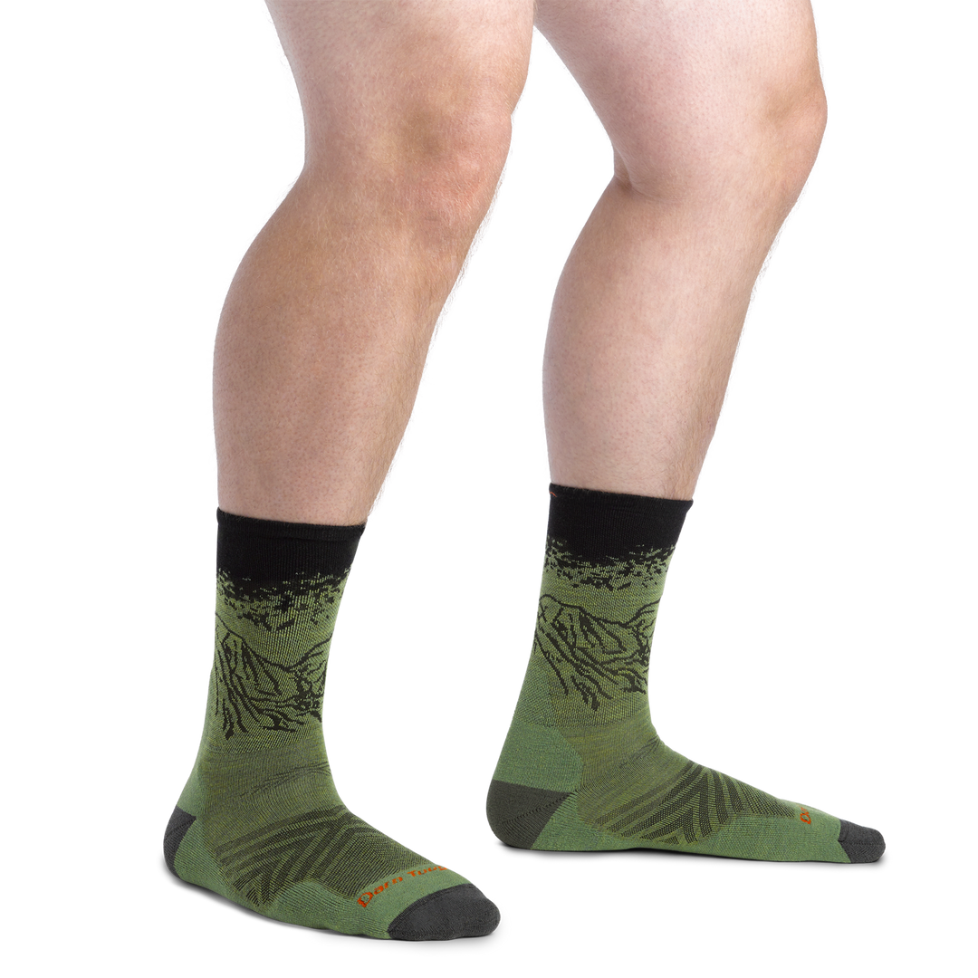 Close up shot of model wearing the men's Vert Micro Crew running sock in Lichen with no shoes on