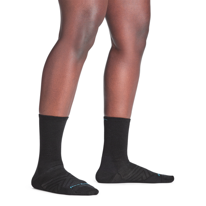 Model standing bare foot in 1068 micro crew running sock in black colorway