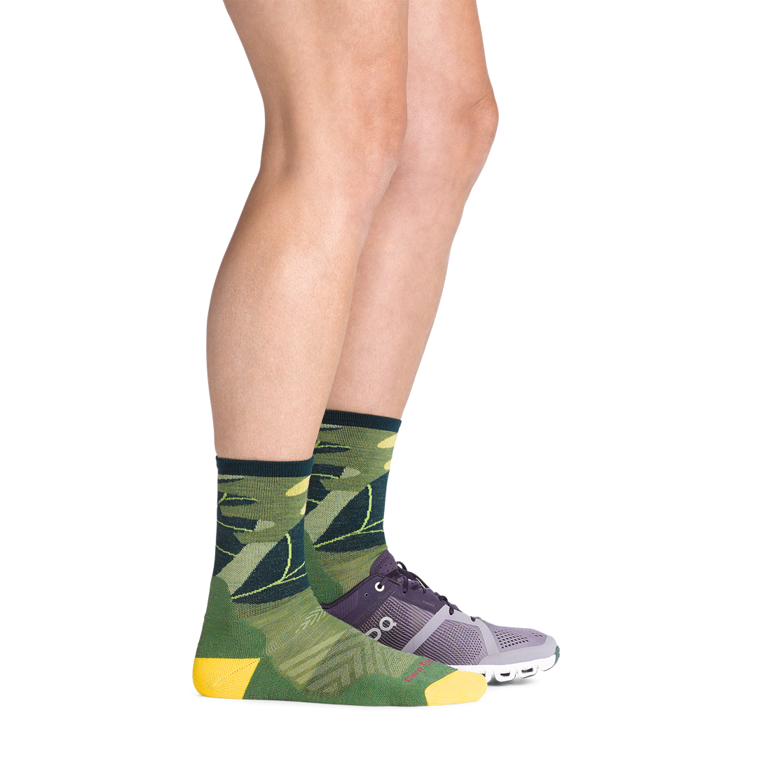 on model image with back foot in sneaker wearing the 1069 run wild micro crew running sock in palm green colorway