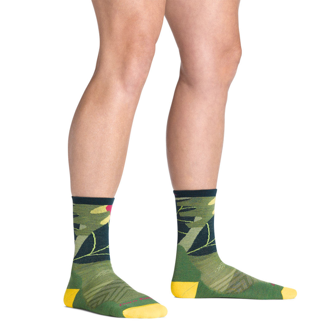 model standing barefoot wearing the 1069 run wild micro crew running sock in palm green colorway