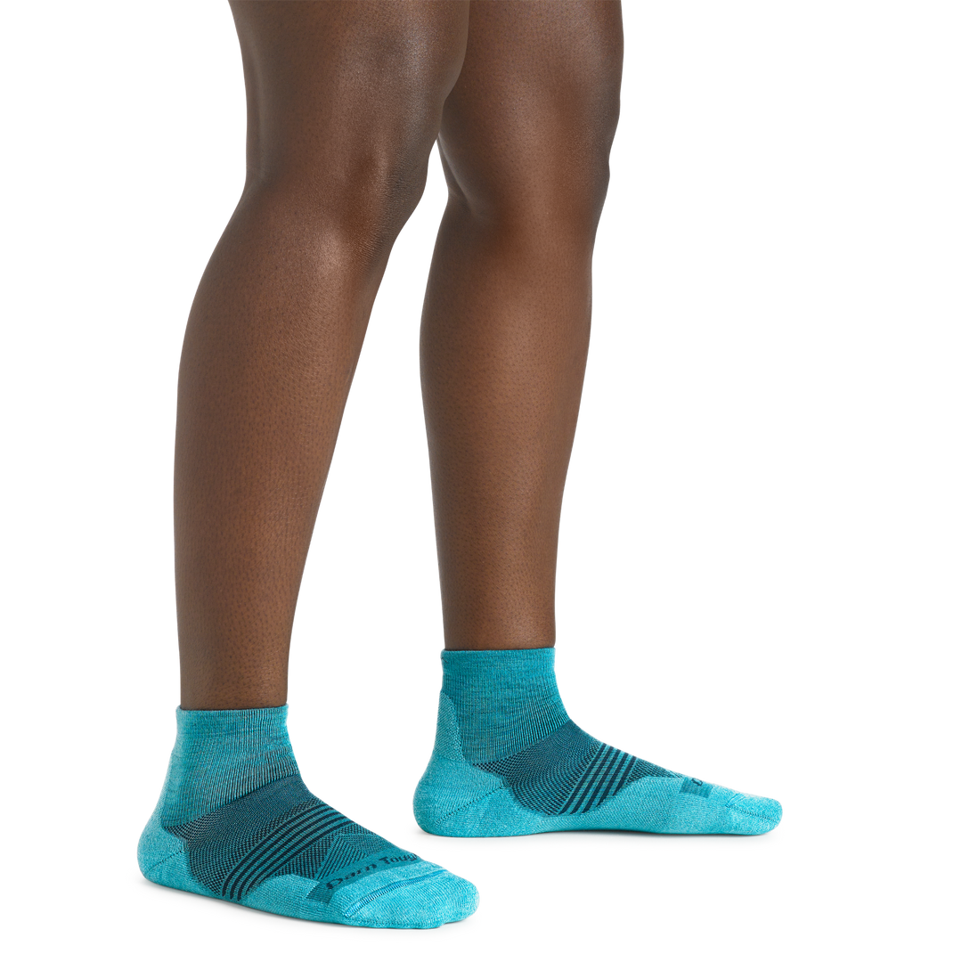 Close up shot of model wearing the women's element quarter height running sock in cyan with no shoes on