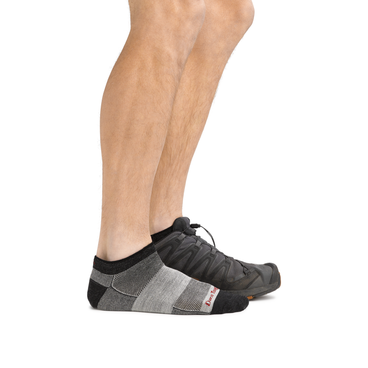 Profile of male legs wearing  1437 No Show Athletic Sock in charcoal and back foot wearing a sneaker