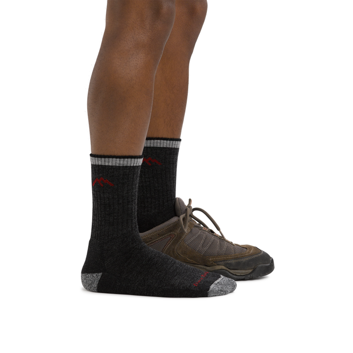 Man wearing Hiker Micro Crew Midweight Hiking Sock in Black, foot in back also wearing a hiking shoe