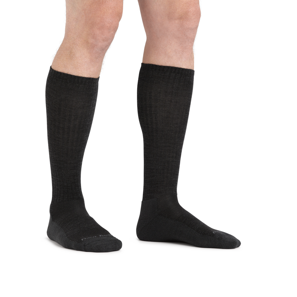 Man standing barefoot wearing The Standard Mid-Calf Lightweight Lifestyle Sock in Black