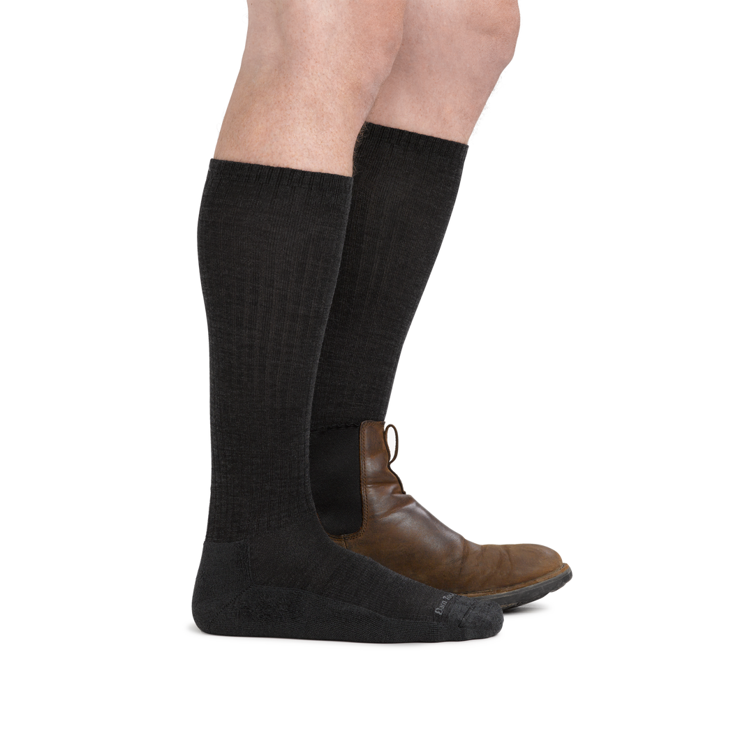 Man wearing The Standard Mid-Calf Lightweight Lifestyle Sock in Black, with back foot in a shoe as well