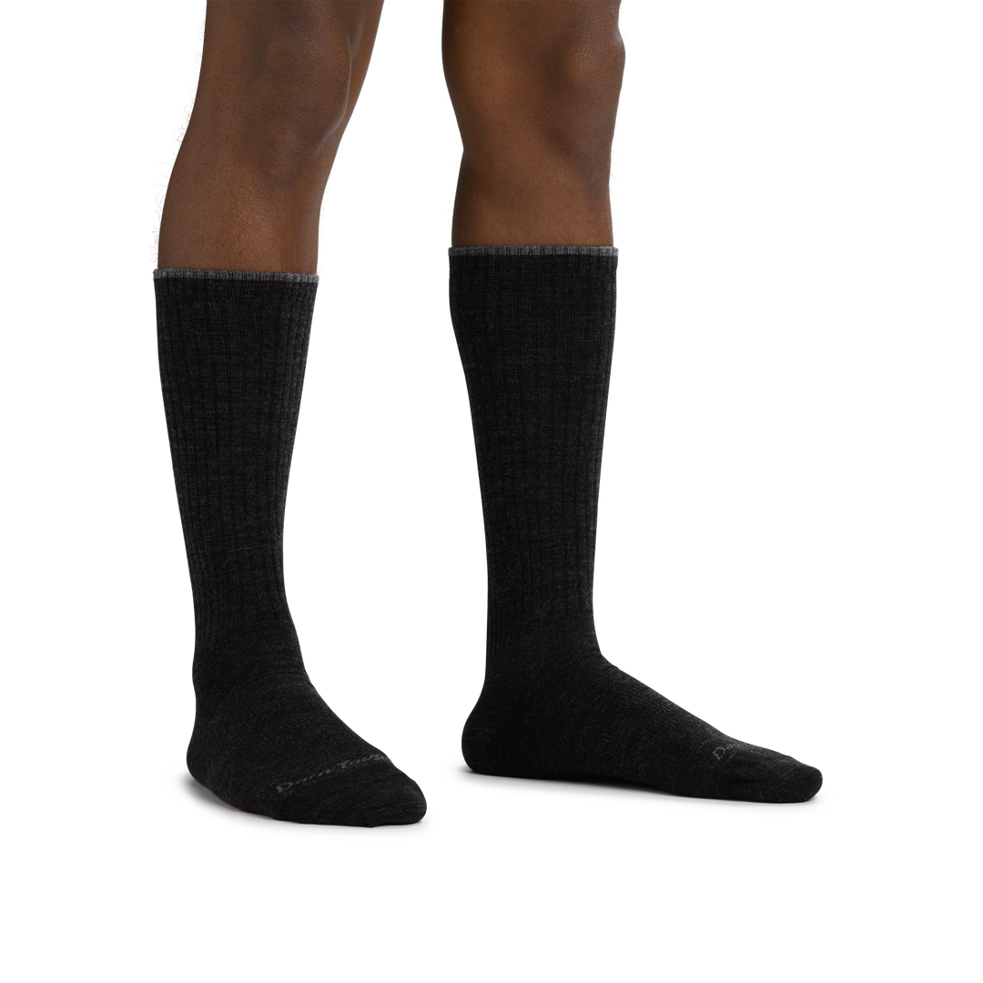 Man standing barefoot wearing The Standard Mid-Calf Lightweight Lifestyle Sock in Black