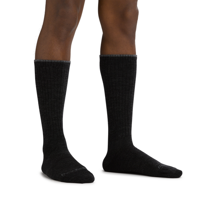 Man standing barefoot wearing The Standard Mid-Calf Lightweight Lifestyle Sock in Black