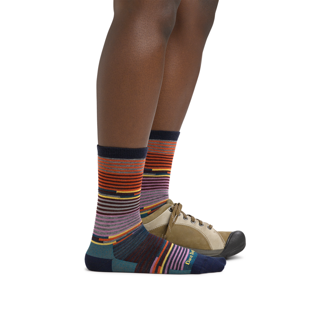 Woman wearing Women's Pixie Crew Lightweight Lifestyle Socks in Navy with one foot in a casual shoe