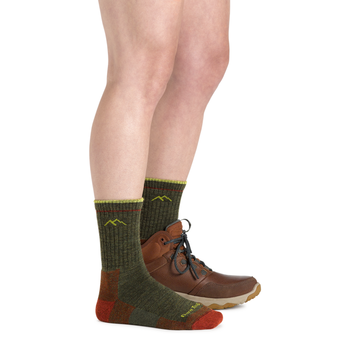 Profile image of a woman's legs, facing right, wearing Women's Hiker Micro Crew Midweight Hiking Socks in Forest and one foot wearing a Hiking boot