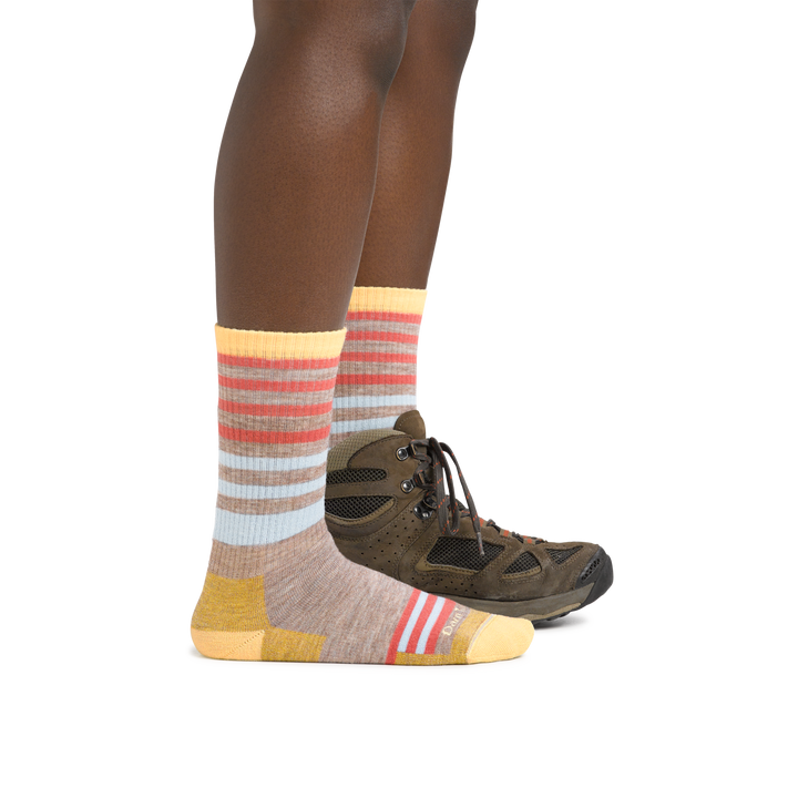 Woman wearing Women's Gatewood Boot Midweight Hiking Sock in Oatmeal and a hiking boot