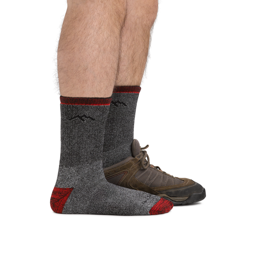 Man facing right, wearing Mountaineering Micro Crew Heavyweight Hiking Socks in Smoke, back foot wearing a hiking boot