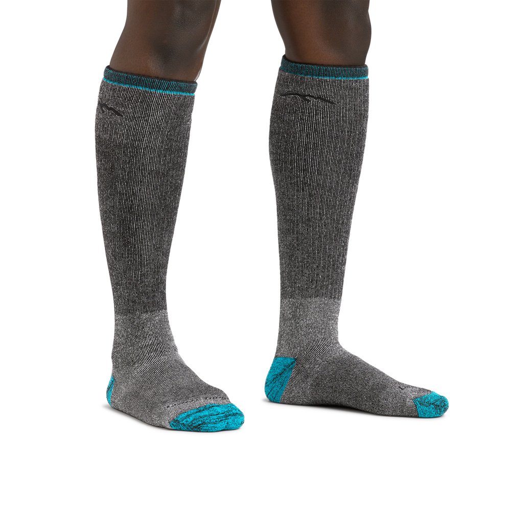 Woman's legs on a white background wearing Women's Mountaineering Over the Calf Heavyweight Hiking Socks in Midnight