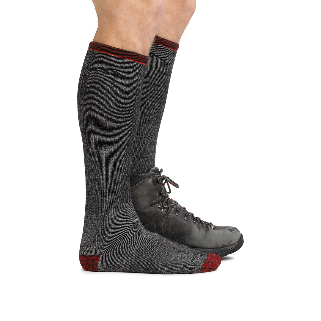 Male legs wearing Mountaineering Over the Calf Heavyweight Hiking Sock in Smoke, back foot wearing a hiking boot