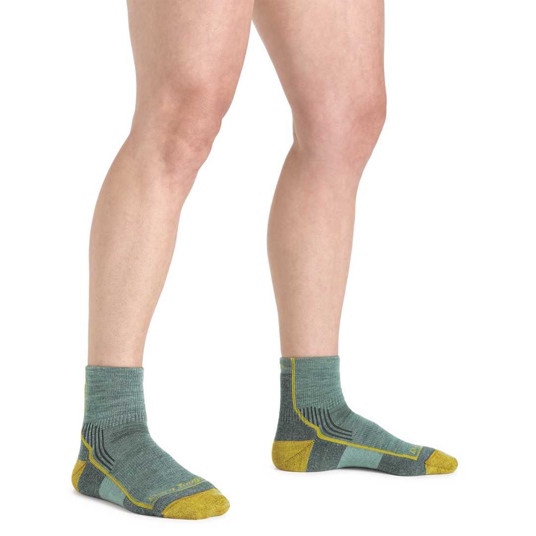 Woman's legs standing on a white background wearing Women's Hiker Quarter Midweight Hiking Socks in sage color