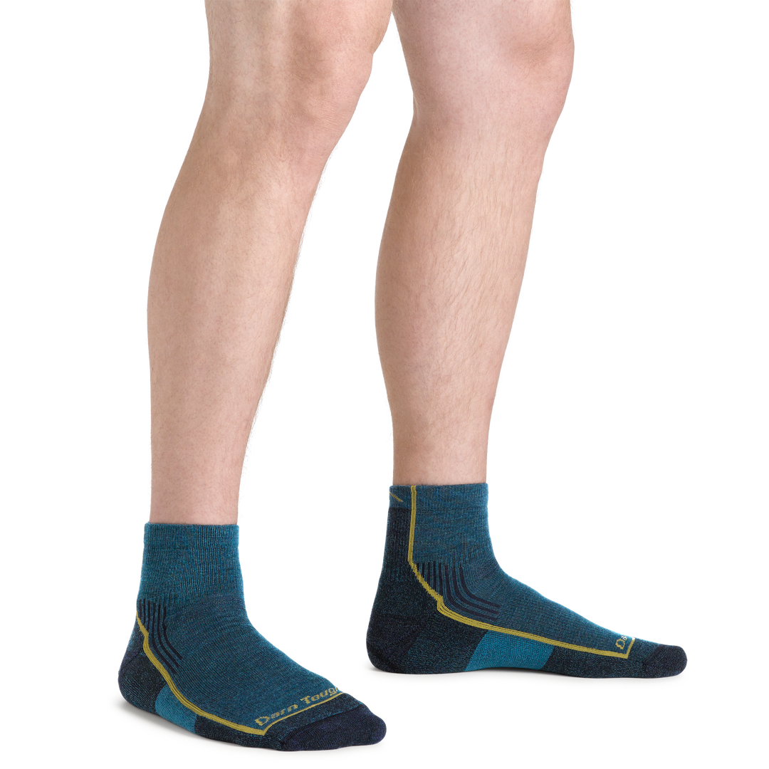 Model's legs standing on a white background wearing Men's Hiker Quarter Midweight Hiking Socks in dark teal color