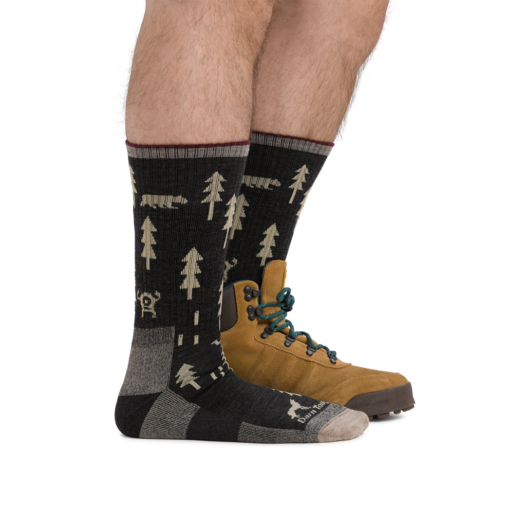Man wearing a hiking boot and ABC Boot Midweight Hiking Socks in Black, showing height of socks is about mid-shin.