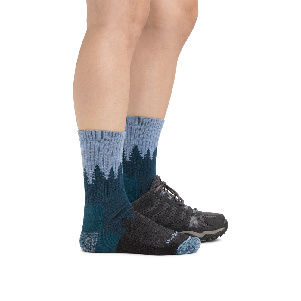 Woman wearing Women's Treeline Micro Crew Midweight Hiking Socks in Blue with one foot in a hiking boot
