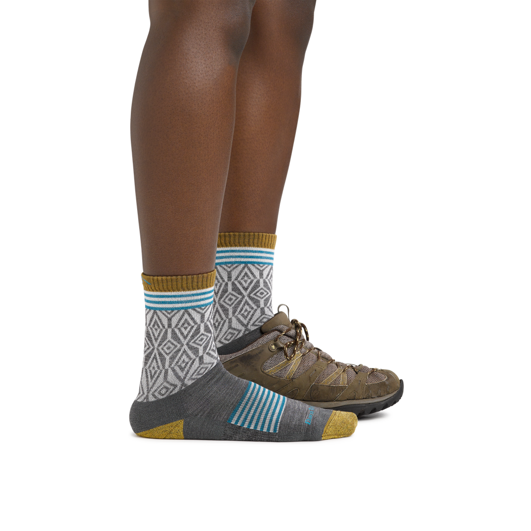 Woman wearing Women's Sobo Micro Crew Lightweight Hiking Socks in Gray with one foot also wearing a hiking boot